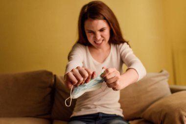 Tıbbi maskeyi yırtan duygusal kadının seçici odağı, karantina konseptinin sonu. 