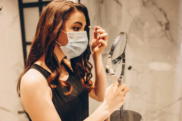 Woman Medical Mask Black Dress Applying Eye Shadow Holding Mirror — Stock Photo, Image