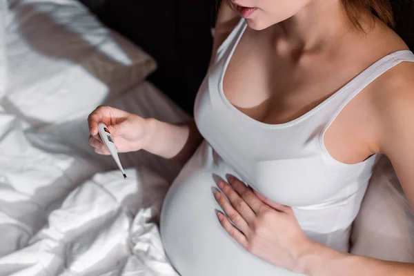Vista Recortada Mujer Embarazada Sosteniendo Termómetro Digital Dormitorio — Foto de Stock