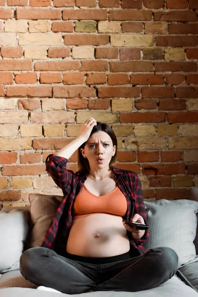 Mujer Alterada Embarazada Tocando Cabeza Sosteniendo Mando Distancia —  Fotos de Stock