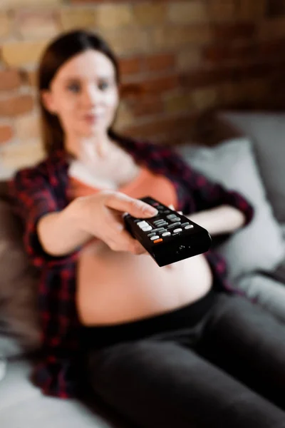 Wybiórcze Skupienie Kobiety Ciąży Trzymającej Pilot Zdalnego Sterowania — Zdjęcie stockowe