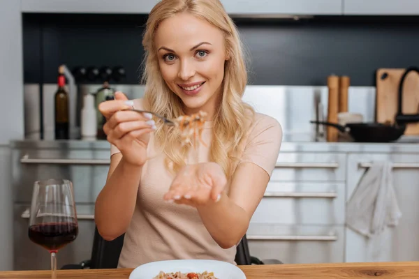 Mujer Alegre Sosteniendo Tenedor Con Fideos Tailandeses Mientras Sonríe Cámara — Foto de Stock