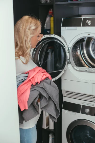 Jovem Loira Dona Casa Segurando Lavanderia Perto Máquina Lavar Aberta — Fotografia de Stock