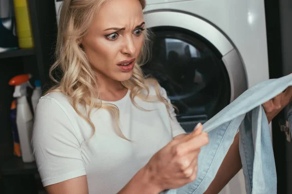 Shocked Housewife Looking Jeans While Standing Washing Machine — Stock Photo, Image