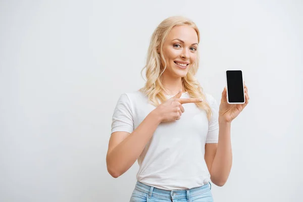 Mujer Feliz Apuntando Teléfono Inteligente Con Pantalla Blanco Mientras Mira — Foto de Stock