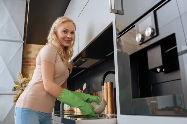 Leende Hemmafru Gummihandskar Tvätta Skål Köket Och Titta Kameran — Stockfoto