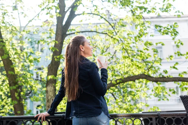 Smiling Young Woman Denim Jacket Holding Cup Coffee Balcony — Stock Photo, Image