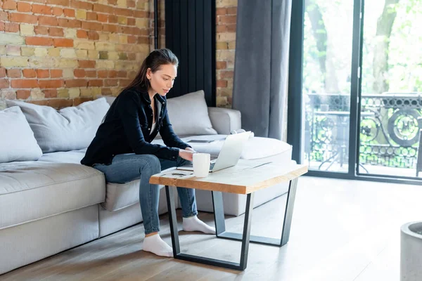 Atractivo Freelancer Utilizando Ordenador Portátil Cerca Taza Mesa Café —  Fotos de Stock