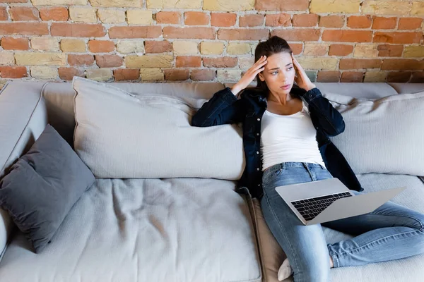 Freelancer Cansado Sentado Sofá Tocando Cabeza Cerca Del Ordenador Portátil — Foto de Stock