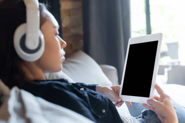 无线耳机中的女孩选择焦点 听音乐和使用空白屏幕的数字平板电脑 — 图库照片