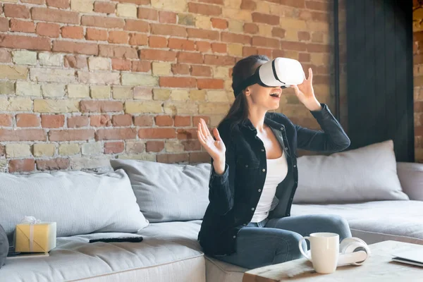 Mujer Emocionada Tocando Auriculares Realidad Virtual Mientras Está Sentado Sofá — Foto de Stock