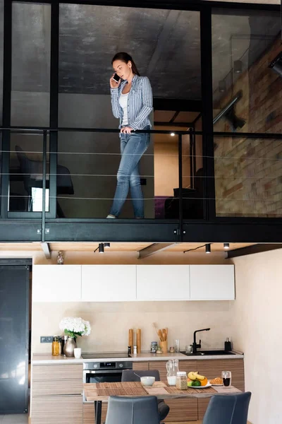 Młoda Kobieta Rozmawia Smartfonie Stojąc Drugim Piętrze Mieszkaniu Dwupoziomowym — Zdjęcie stockowe