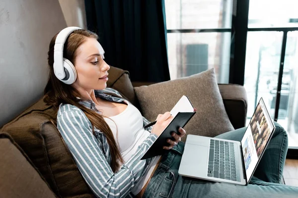 Kyiv Ukraine April 2020 Attractive Woman Wireless Headphones Writing Notebook — Stock Photo, Image