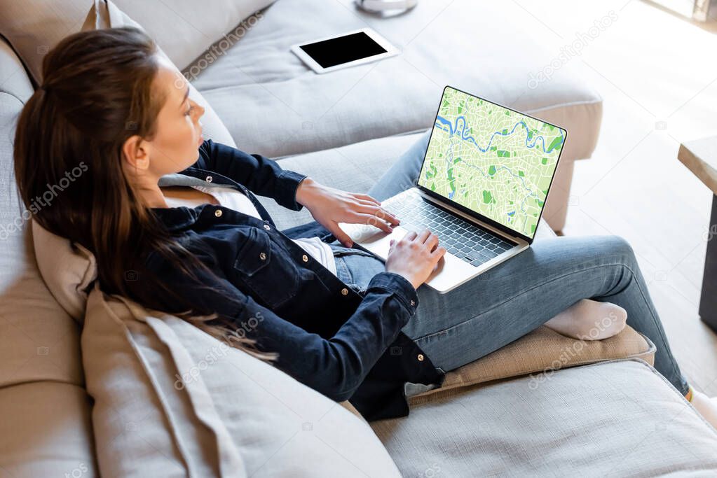 selective focus of freelancer using laptop with online map near digital tablet with blank screen 