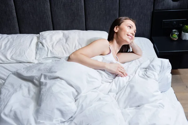 Χαρούμενη Γυναίκα Κοιτάζει Μακριά Και Ξαπλωμένη Στο Κρεβάτι — Φωτογραφία Αρχείου