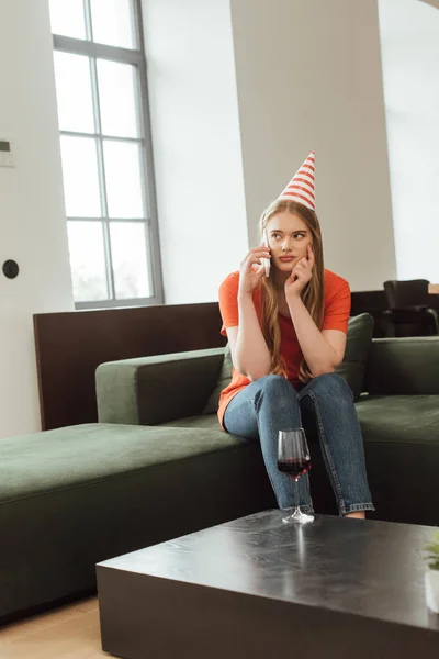 Selective Focus Displeased Girl Party Cap Sitting Sofa Talking Smartphone — Stock Photo, Image