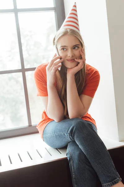 Happy Girl Party Cap Sitting Window Sill Talking Smartphone — Stock Photo, Image