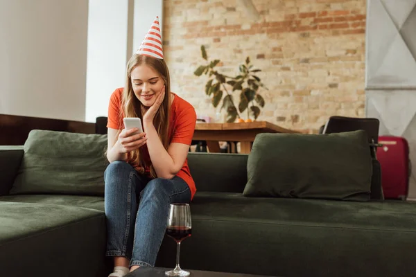 Selective Focus Cheerful Young Woman Party Cap Using Smartphone — Stock Photo, Image