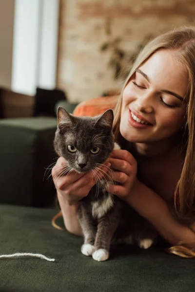 Šťastná Mladá Žena Dotýkající Roztomilé Kočky Obývacím Pokoji — Stock fotografie
