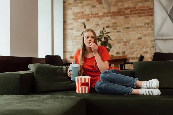 Atrakcyjna Dziewczyna Jedząc Popcorn Trzymając Jednorazowy Kubek Oglądając Film Salonie — Zdjęcie stockowe