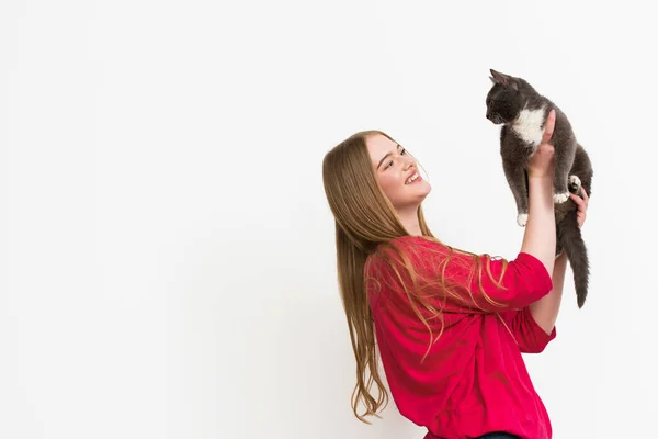 一个快乐的年轻女人抱着一只毛茸茸的猫 它被白色隔离着 — 图库照片