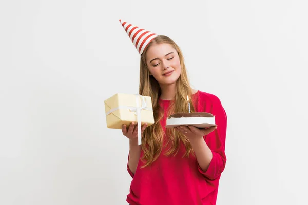 Menina Feliz Boné Festa Olhando Para Bolo Aniversário Segurando Presente — Fotografia de Stock