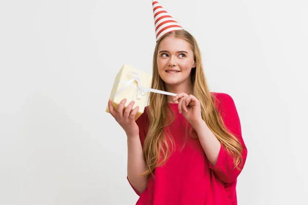 Curious Girl Party Cap Touching Ribbon Present Isolated White — Stock Photo, Image