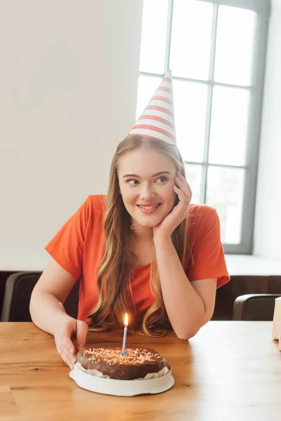 Alegre Mujer Partido Tapa Mirando Lejos Cerca Delicioso Pastel Cumpleaños —  Fotos de Stock