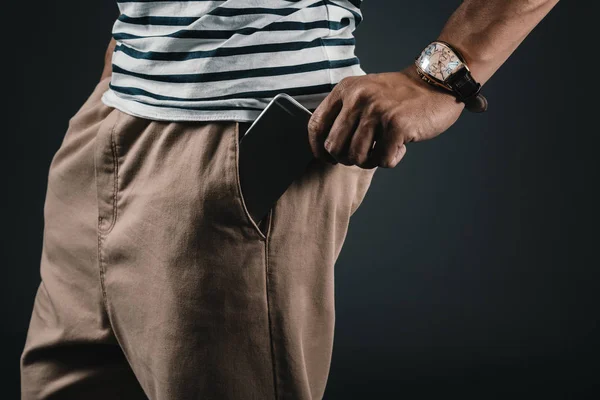 Man putting smartphone into pocket — Stock Photo