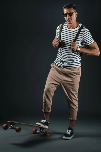 Стильный мужчина со скейтбордом — стоковое фото
