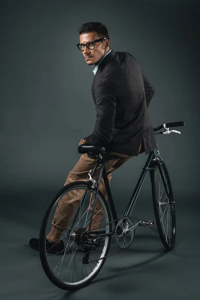 Молодой стильный бизнесмен сидит на велосипеде — стоковое фото