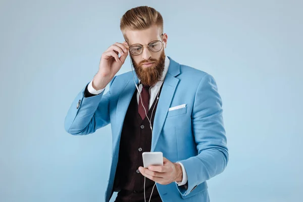 Elegante uomo in auricolare con smartphone — Foto stock