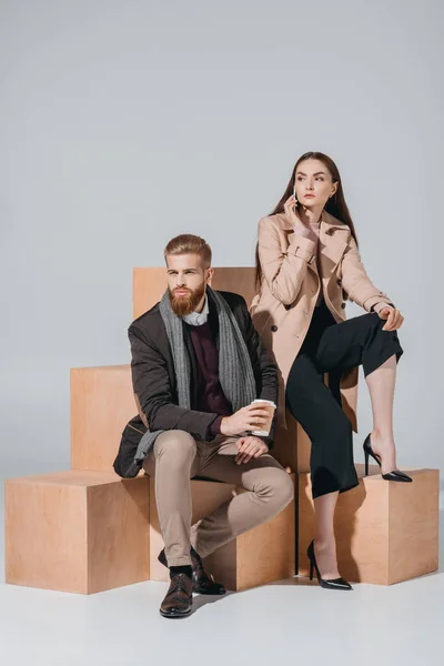 Pareja elegante con café para llevar y teléfono inteligente - foto de stock