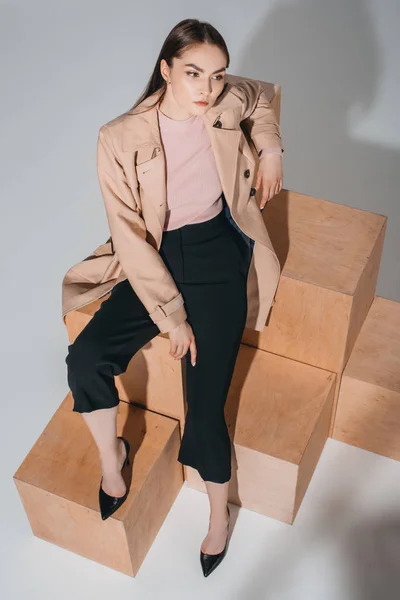 Femme à la mode assis sur des blocs de bois — Photo de stock