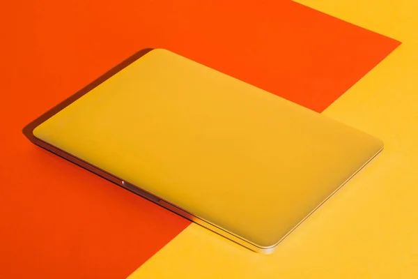 Computer portatile su giallo e rosso — Foto stock