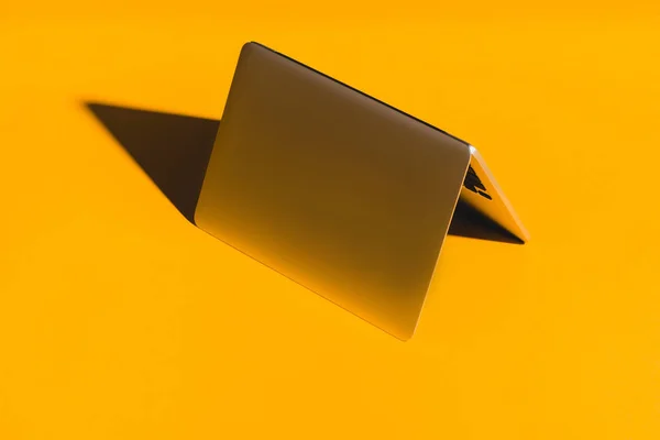 Overturned laptop on yellow — Stock Photo
