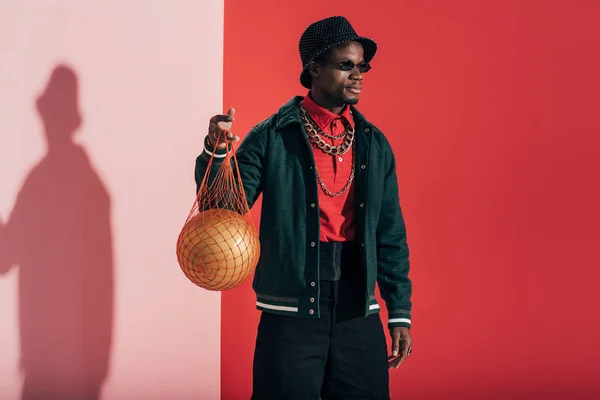 Hombre con bola de oro en bolsa de cuerda - foto de stock