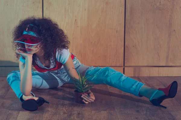 Fashionable woman with plant in flowerpot — Stock Photo