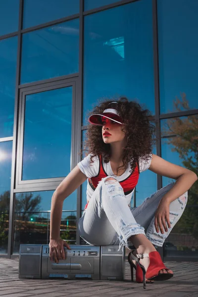 Attractive woman sitting on boombox — Stock Photo