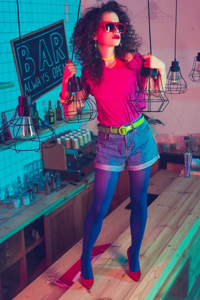 Woman in sunglasses standing on counter — Stock Photo