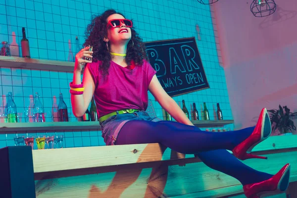 Femme souriante avec coup de feu dans le bar — Photo de stock