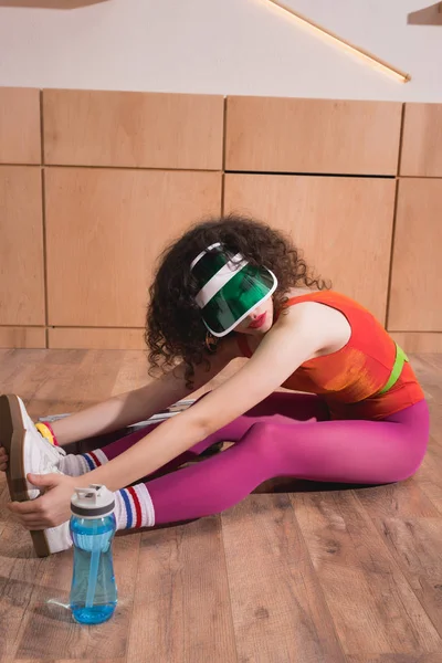 Спортивная женщина растягивается на полу — стоковое фото