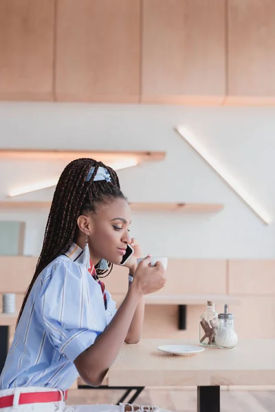 African american woman talking on phone in cafe — Stock Photo