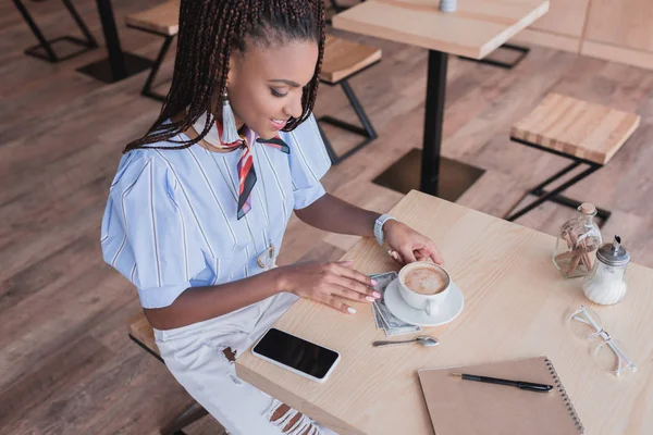Donna afro-americana che beve caffè nel caffè — Foto stock