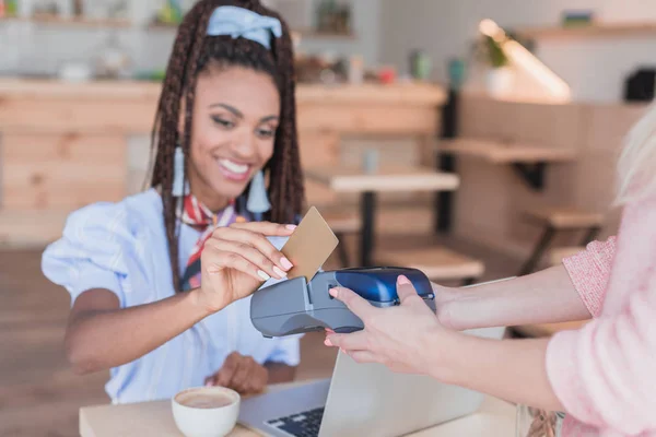 Mujer afroamericana pagando con tarjeta - foto de stock