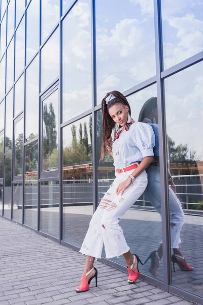 Donna appoggiata alla parete di vetro — Foto stock