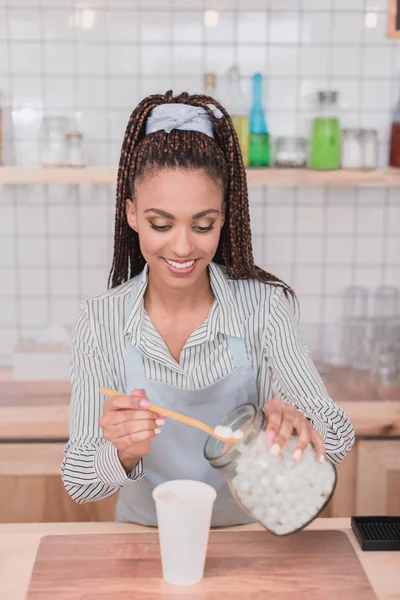 Barista poner malvaviscos en taza - foto de stock