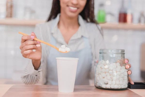 Barista putting marshmallows into cup — Stock Photo