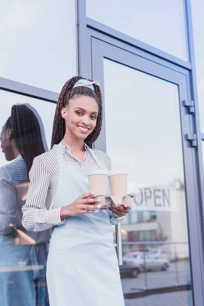 Barista sosteniendo dos tazas de papel - foto de stock