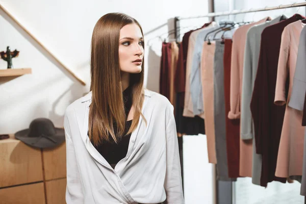 Girl choosing clothes in boutique — Stock Photo